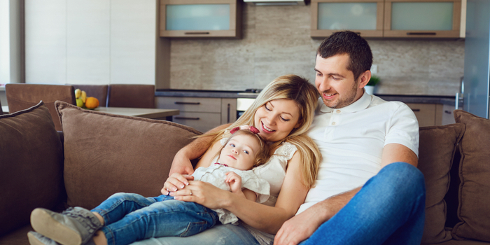 Happy man, woman and child on sofa