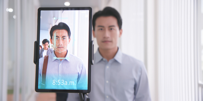 A young Asian businessman is scanned by facial recognition software